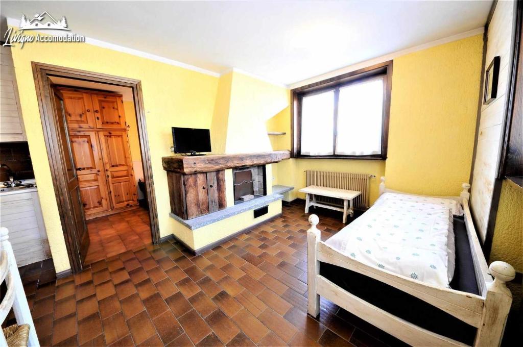 een kamer met een slaapkamer met een bed en een open haard bij Baite Costaccia App 4 in Livigno