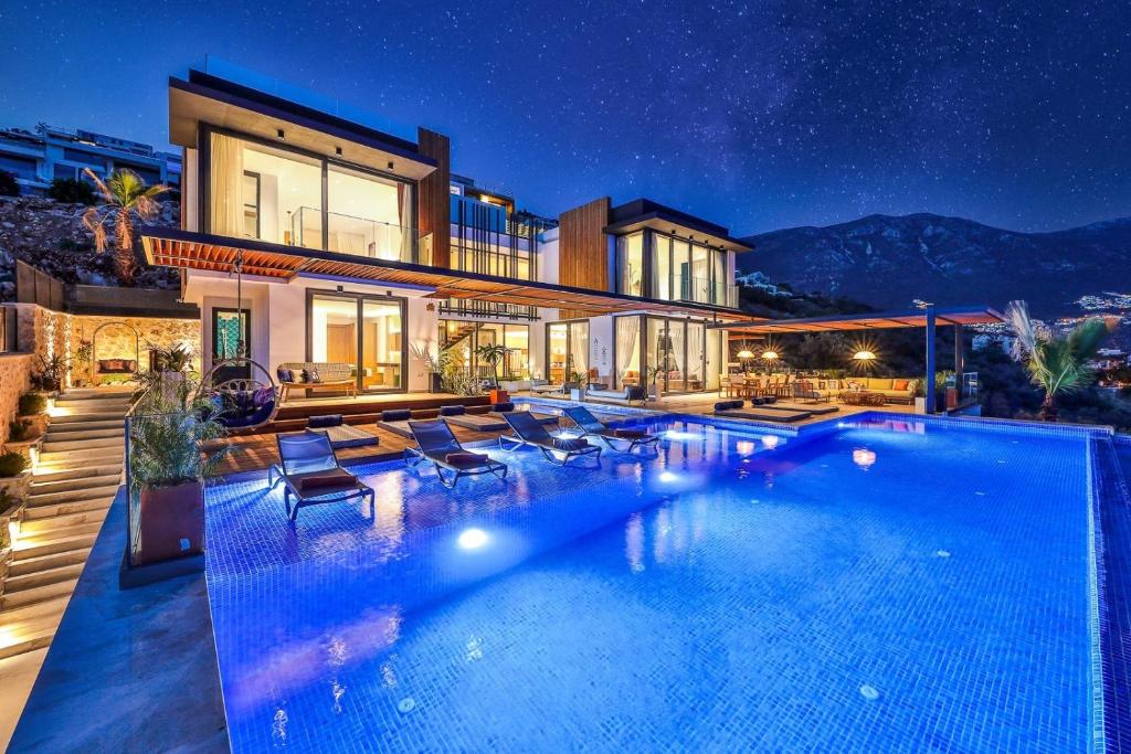 a house with a large swimming pool at night at Villa Pax - Kalkan Villa in Kas