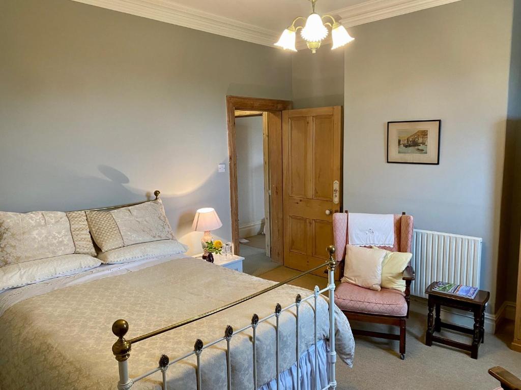 um quarto com uma cama e uma cadeira em Golborne Manor Bed and Breakfast em Chester
