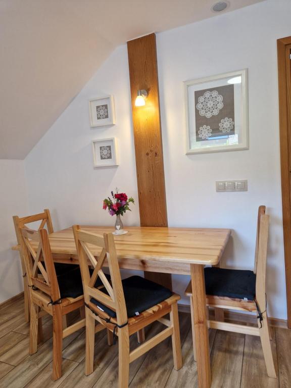 a dining room with a wooden table and chairs at Kukurooms in Koniaków