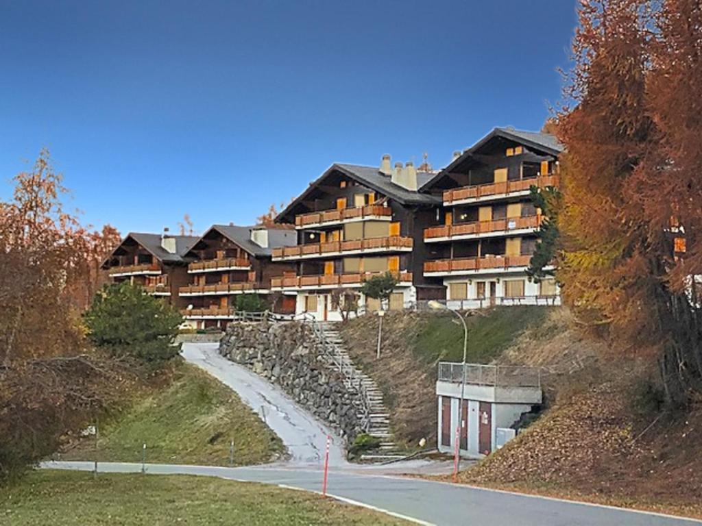 un grand bâtiment sur le côté d'une colline dans l'établissement Les Mayens de l'Ours - At the foot of Piste de l'Ours' slope!, à Agettes