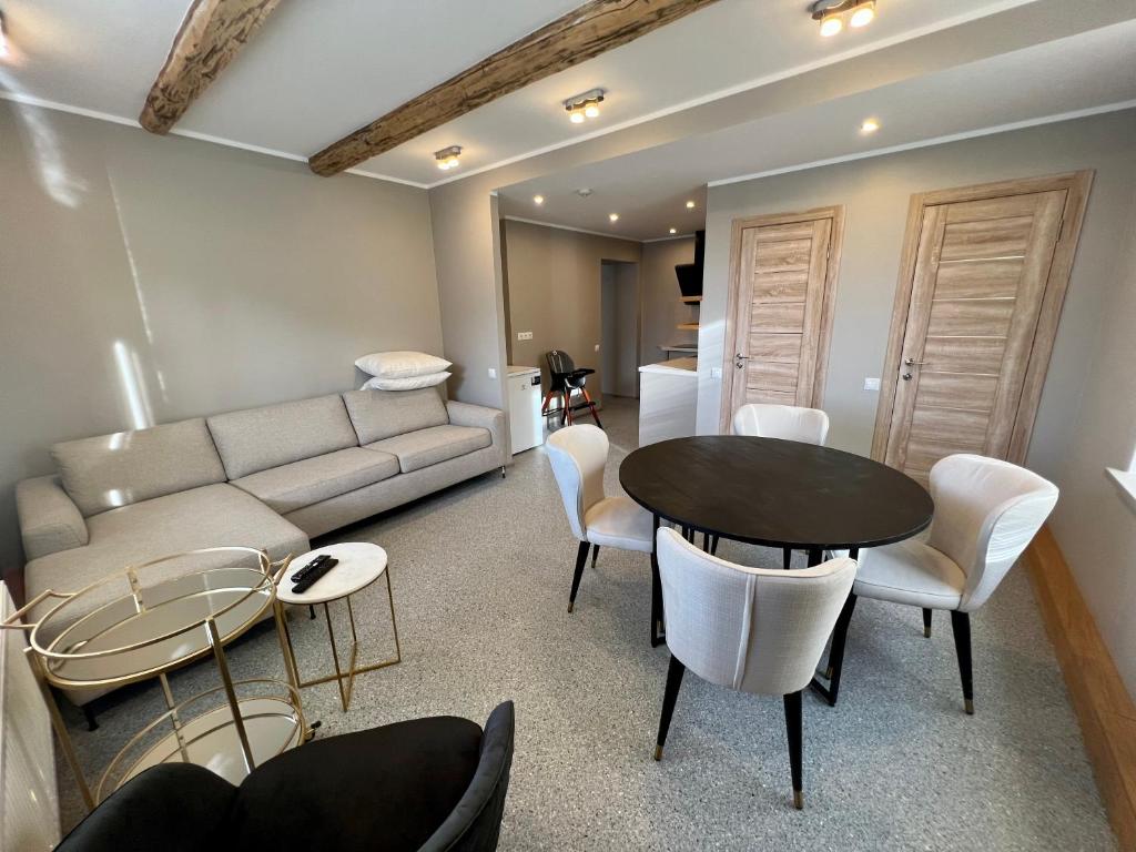 a living room with a couch and a table and chairs at Apartments in Dobele city center - Pilsētas Māja in Dobele