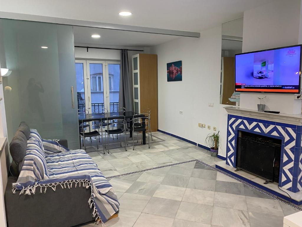 sala de estar con chimenea y TV en Apartamento Medina Puerto Sherry, en El Puerto de Santa María