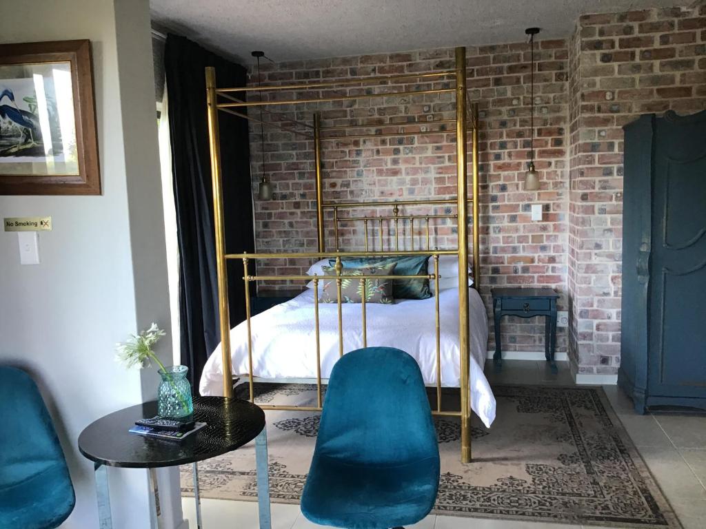 a bedroom with a bed and a brick wall at Welgemoed Villa in Bellville