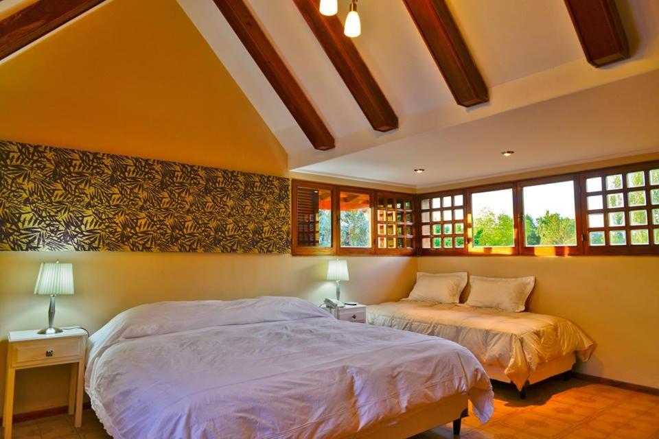 um quarto com 2 camas e 2 janelas em CASA VILLA LOS SAUCES em Luján de Cuyo