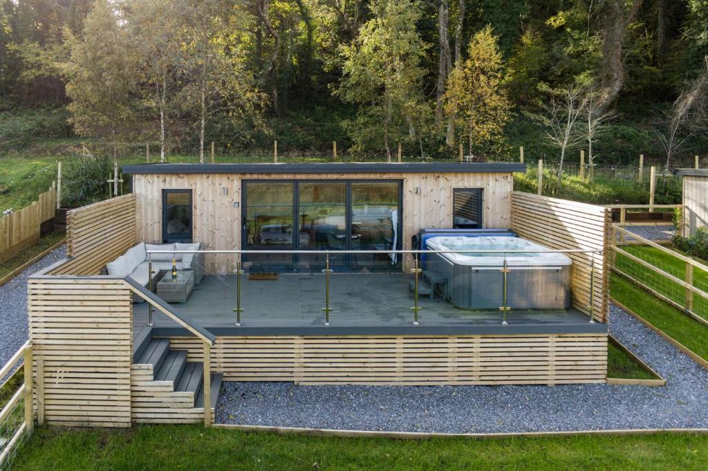 a house with a large deck with a hot tub at The Langland Bay Lookout - 1 Bed Cabin - Landimore in Gowerton