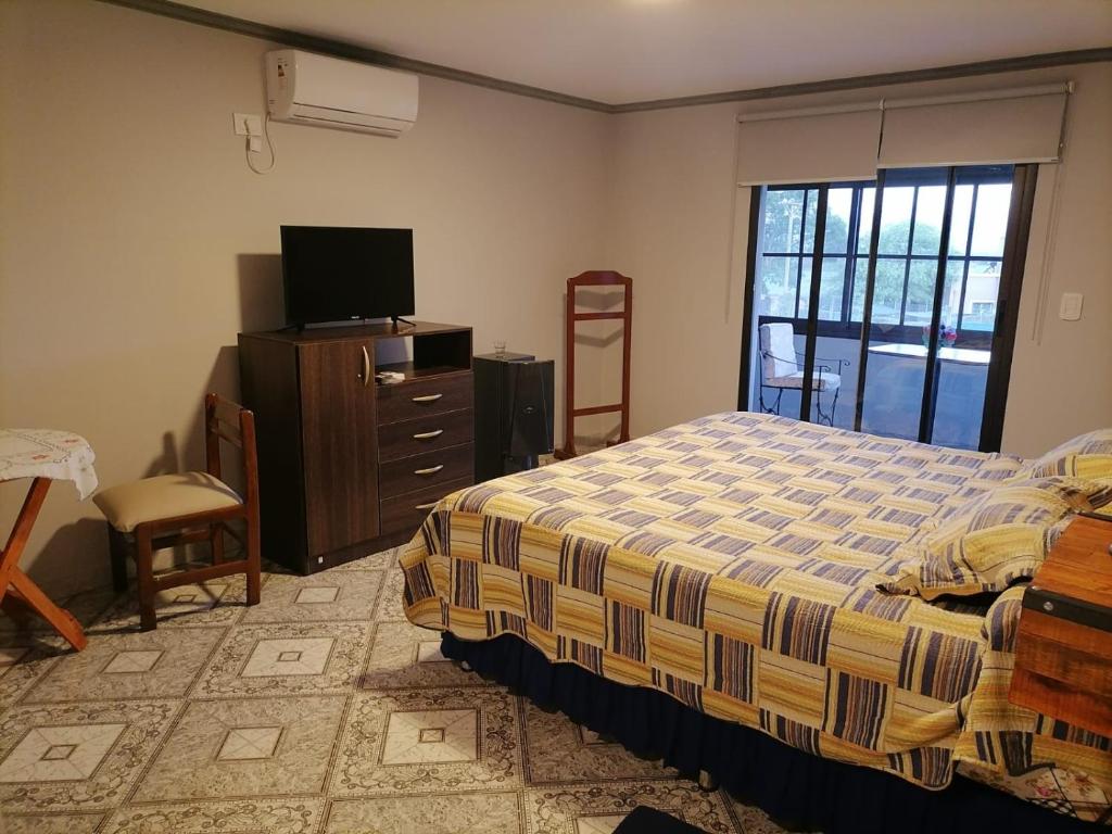 een slaapkamer met een bed, een tv en een raam bij Las Tres Marías in Salta