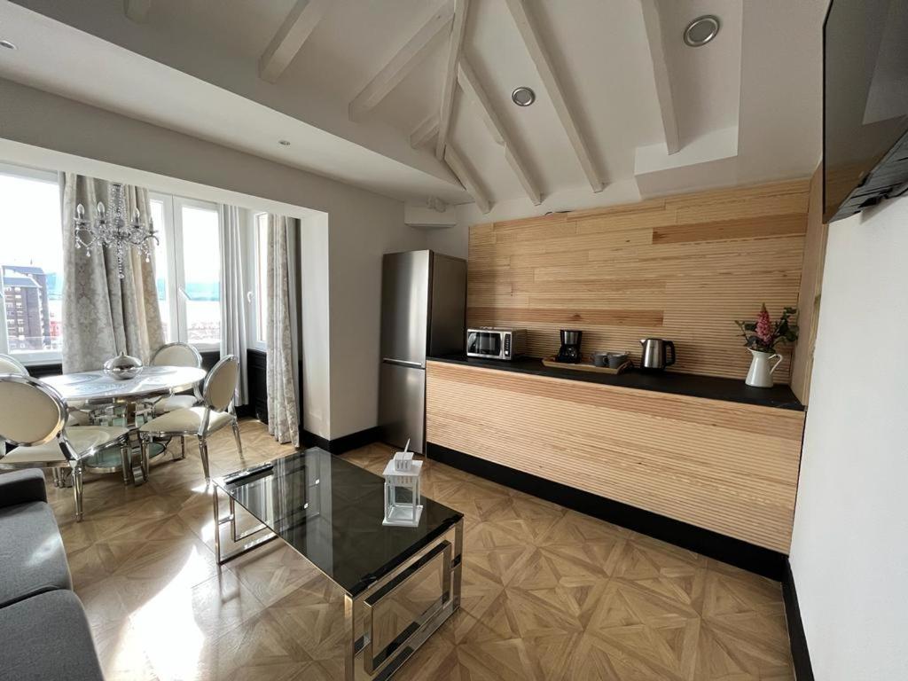 a living room with a table and a refrigerator at Hotel Royal Suite Santander in Santander