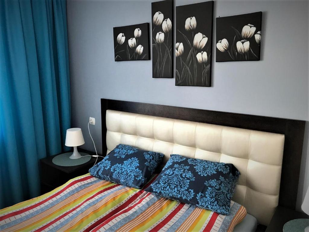 a bedroom with a bed with four pictures on the wall at Apartamenty Rodzinne Krokowa in Krokowa