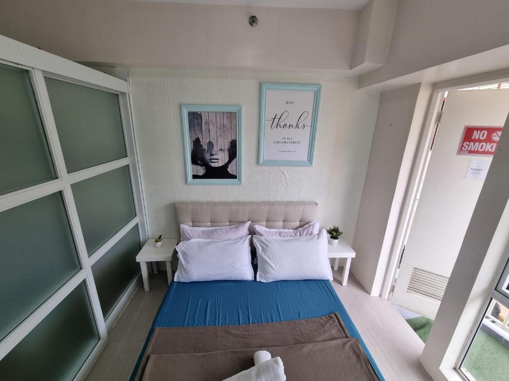 a small bedroom with a bed and two windows at 4 pax Tagaytay Prime Staycation WIFI NETFLIX and light cooking FREE VIEWDECK in Tagaytay
