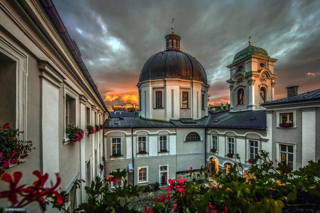 un edificio con una torre dell'orologio sopra di Gästehaus im Priesterseminar Salzburg a Salisburgo