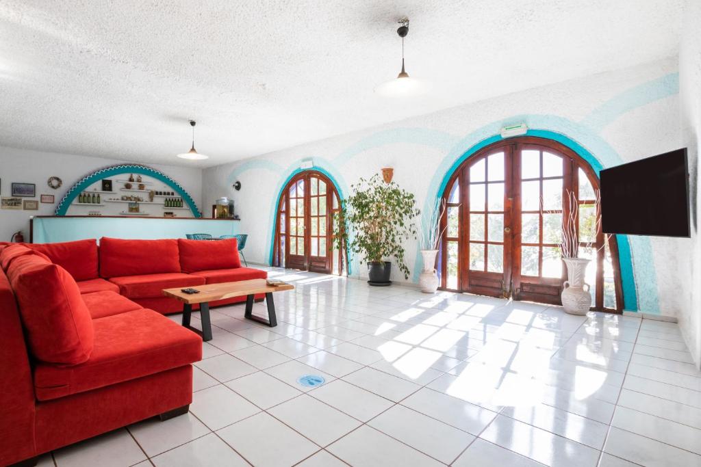 a living room with a red couch and a table at Poseidon Blue Gastronomy Hotel in Afiartis