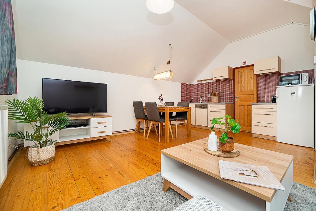 een keuken en een woonkamer met een tafel en een televisie bij Horský apartmán Dolní Morava in Dolní Morava