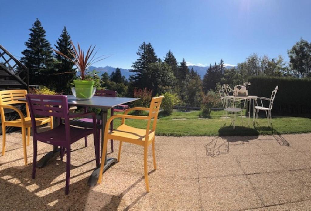 une table et des chaises assises sur une terrasse dans l'établissement My cosy flat in the mountains, à Anzère