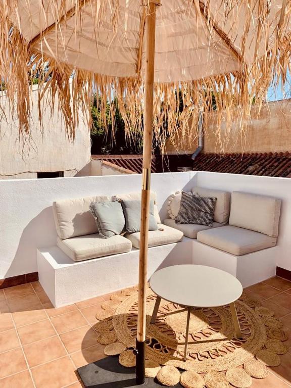 uma sala de estar com um sofá, uma mesa e um guarda-chuva em Casita 10 Málaga, holiday home with roof terrace em Málaga
