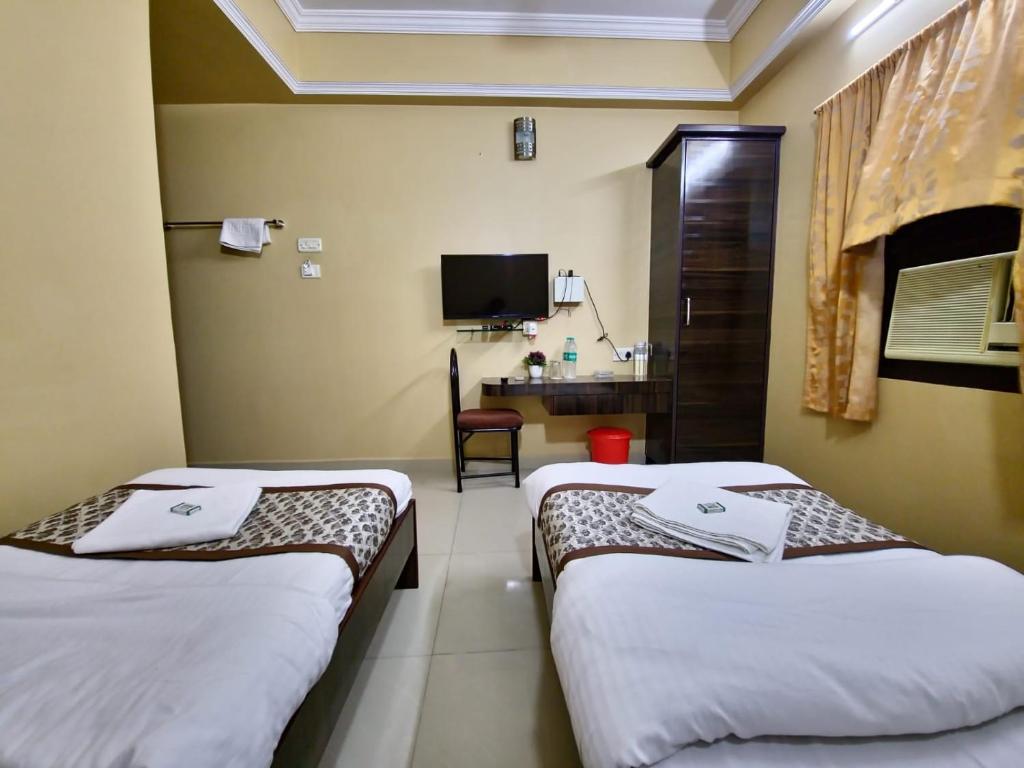 a hotel room with two beds and a desk at BHIMAS INN -Puratchi Thalaivar Dr M G Ramachandran Central Railway Station Chennai in Chennai