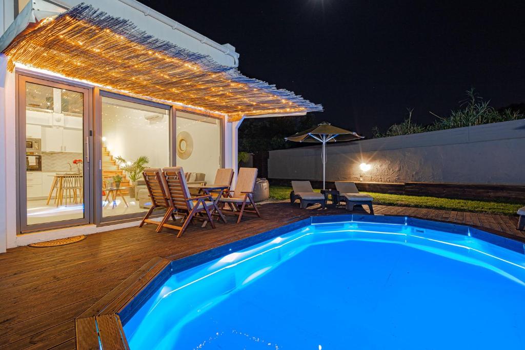 a backyard with a swimming pool and a table and chairs at Cocoon Luxury Villas in Maleme