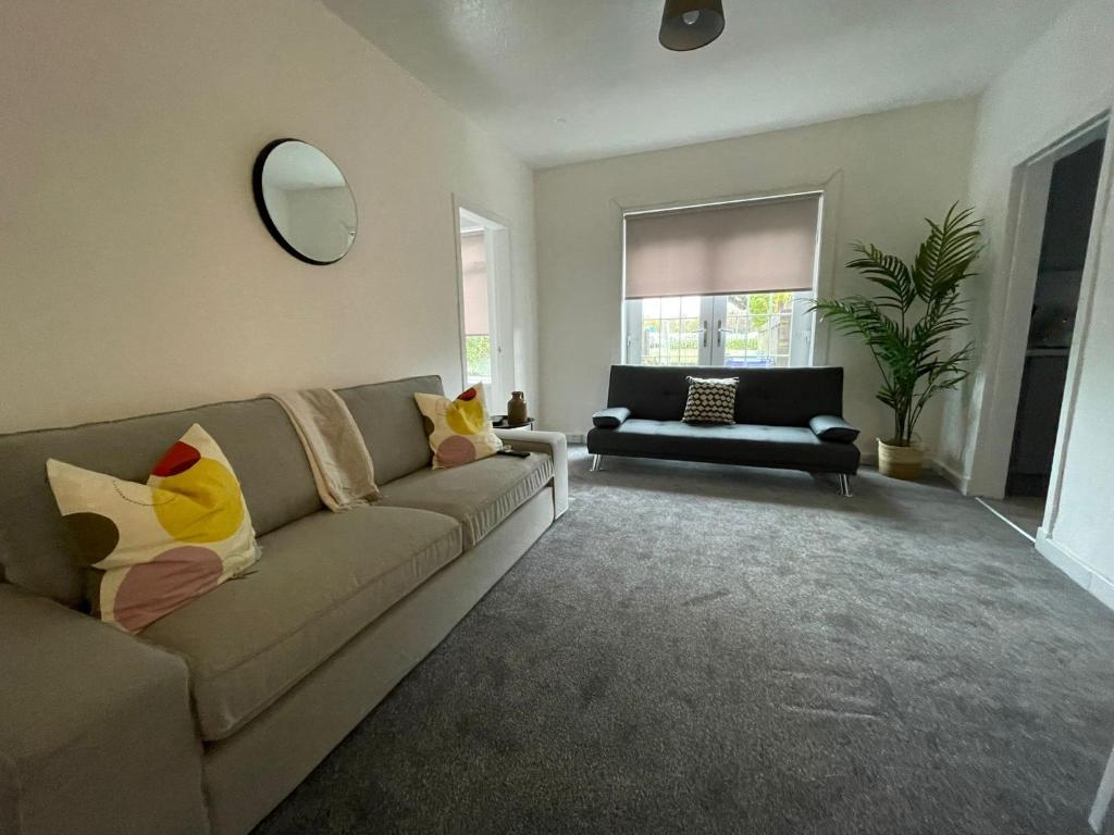 a living room with a couch and a mirror at Cardonald House in Glasgow
