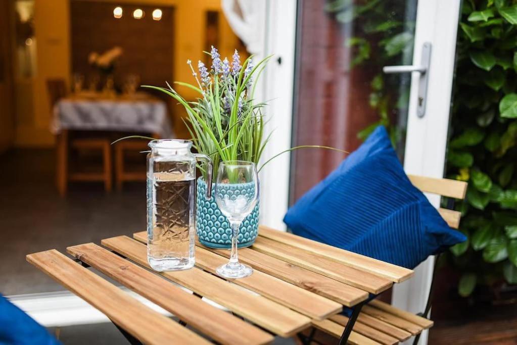 a wooden table with a glass vase and a vase of flowers at Beautiful Large 4 Bedrooms house in central Southampton in Southampton