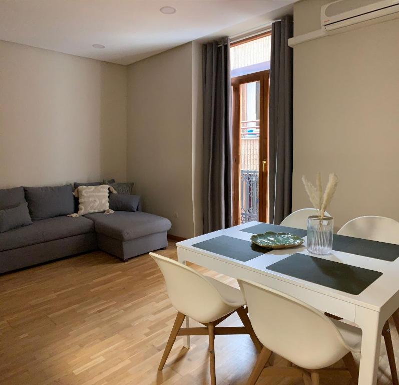 a living room with a table and chairs and a couch at Plaza Ayuntamiento Apartment in Valencia