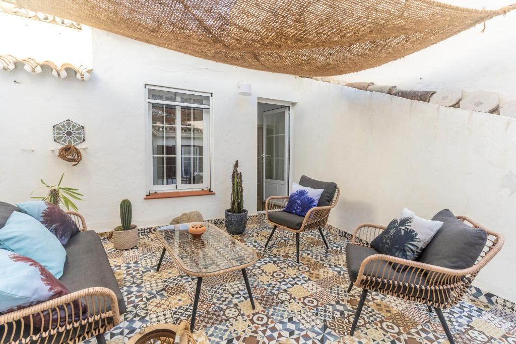 a patio with chairs and a table on a tiled floor at Casa Blanca in Estepona