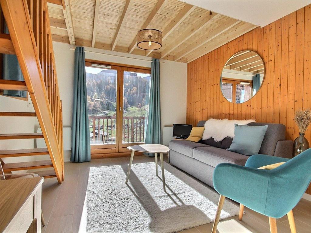 un salon avec un canapé et une table dans l'établissement Duplex rénové 6 personnes avec balcon, à Plagne 1800 - FR-1-455-224, à La Plagne Tarentaise