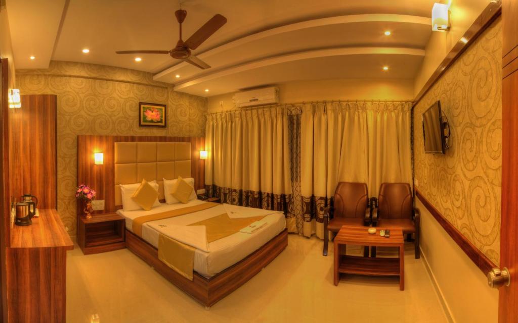 a bedroom with a large bed in a room at Hotel Aditya in Mysore