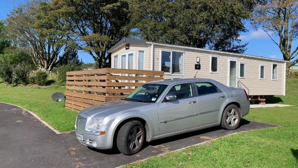 a silver car parked in front of a tiny house at 3 Bedrooms Loch Views Heated Pool Close To Beaches in Newton Stewart