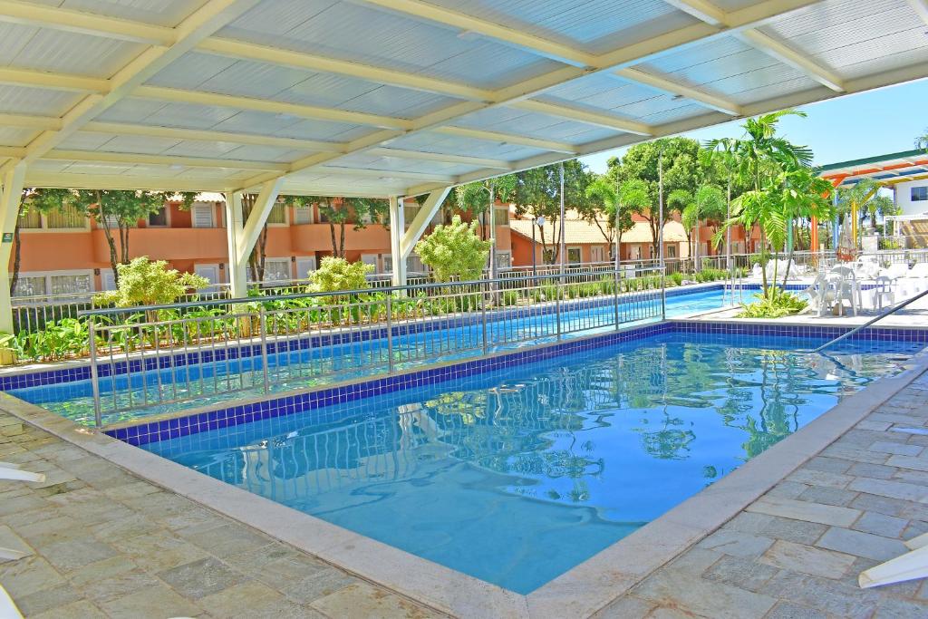 een zwembad in een resort met een luifel bij diRoma Fiori 160 Conforto e muita diversão in Caldas Novas