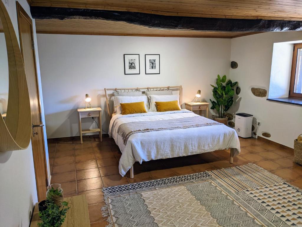 1 dormitorio con 1 cama con almohadas amarillas y 2 mesas en Casa Canela apartment and pool., en Serpins