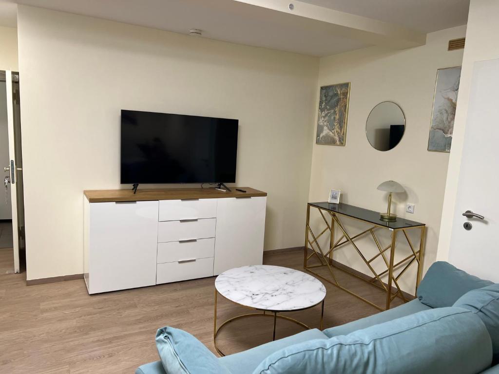 a living room with a blue couch and a tv at Souterrain Studio-Apartment in Nuremberg