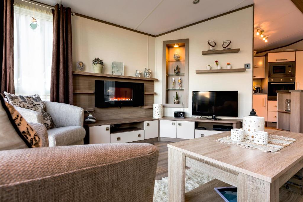 a living room with a couch and a tv and a table at Koie Holiday Home in Stranda