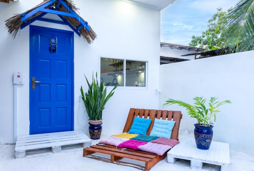 a blue door and a bench in front of a house at Villa Boheme in Ukulhas