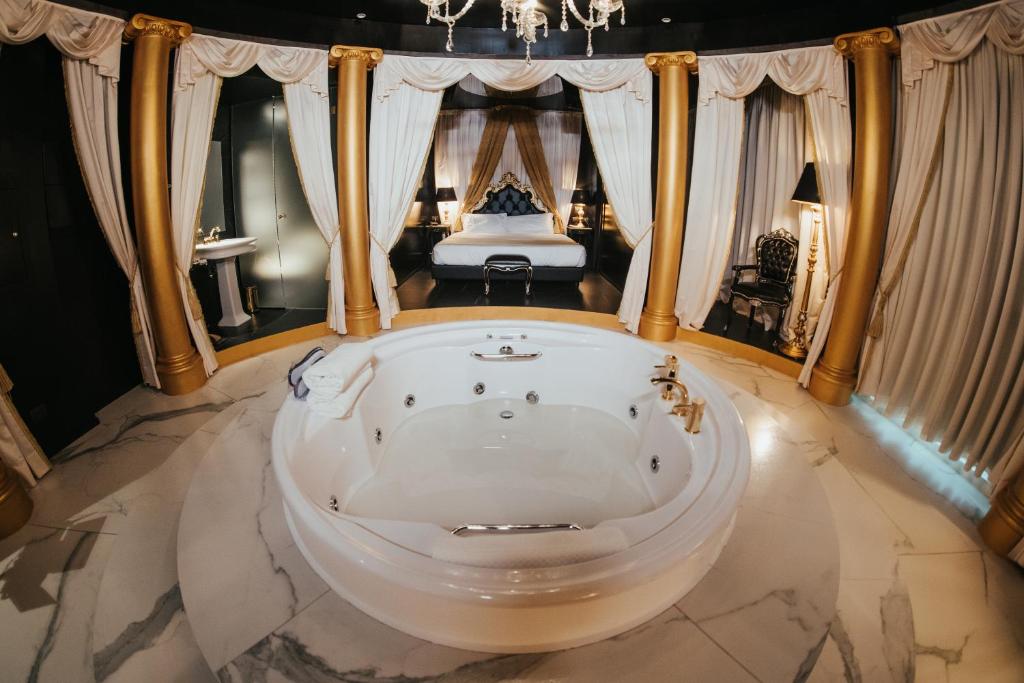 een bad in een kamer met een bed bij Emotional Grand Motel in Fontaneto dʼAgogna