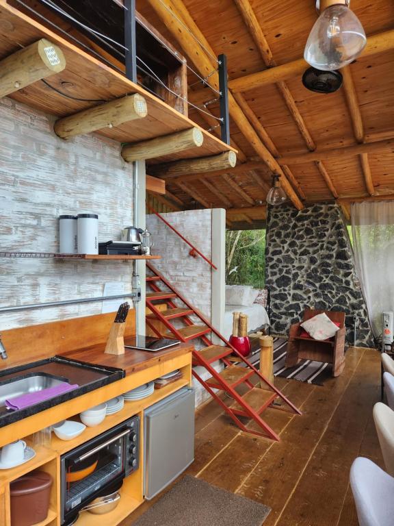 a kitchen with a stove and a staircase in a room at Tiny Houses O Olival - aluguel temporada in Cunha