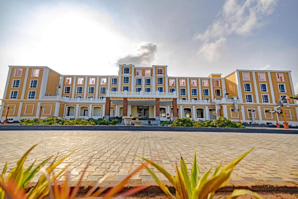 a large building with a courtyard in front of it at Hotel SRM Grandeurs in Tudiyalūr
