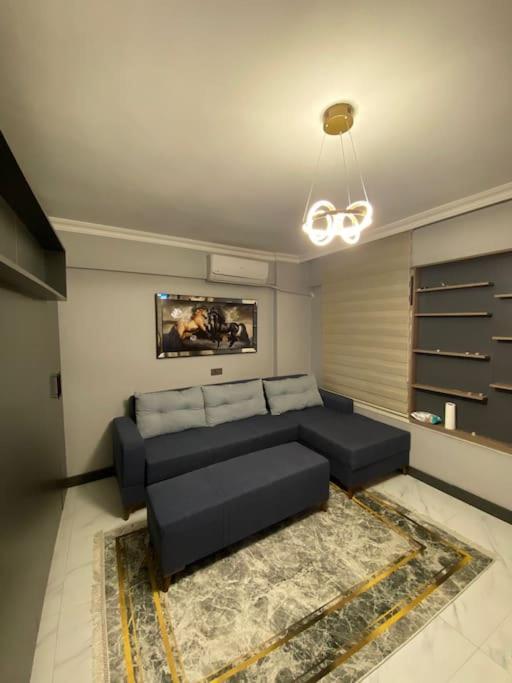 sala de estar con sofá negro y alfombra en Merkezi konumda harika butik daire en Estambul