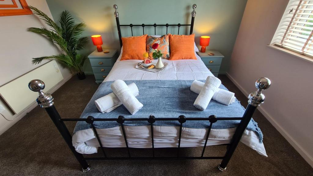 a bedroom with a black bed with orange pillows at The Kingfisher, by Spires Accommodation a great place to stay for Drayton Manor Park and The NEC in Kingsbury