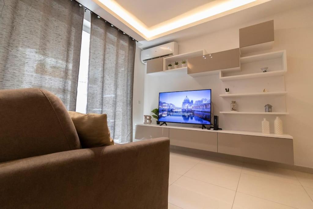 een woonkamer met een bank en een televisie bij Lovely Modern 1 Bedroom Apartment in San Gwann in San Ġwann
