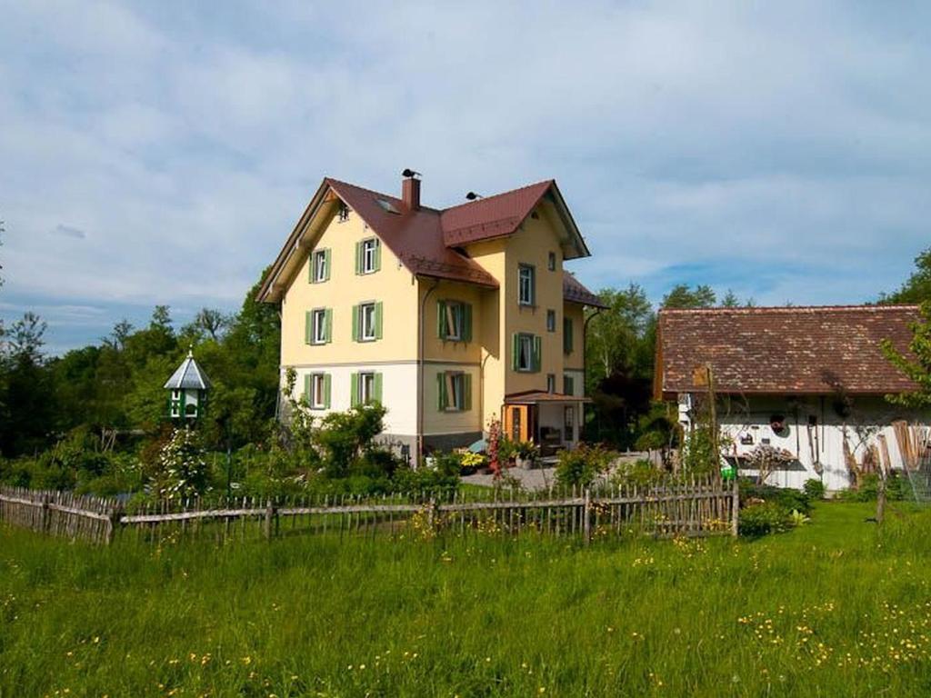 ein großes gelbes Haus auf einem grünen Rasen in der Unterkunft Haus zum Nussbaum in Lindau