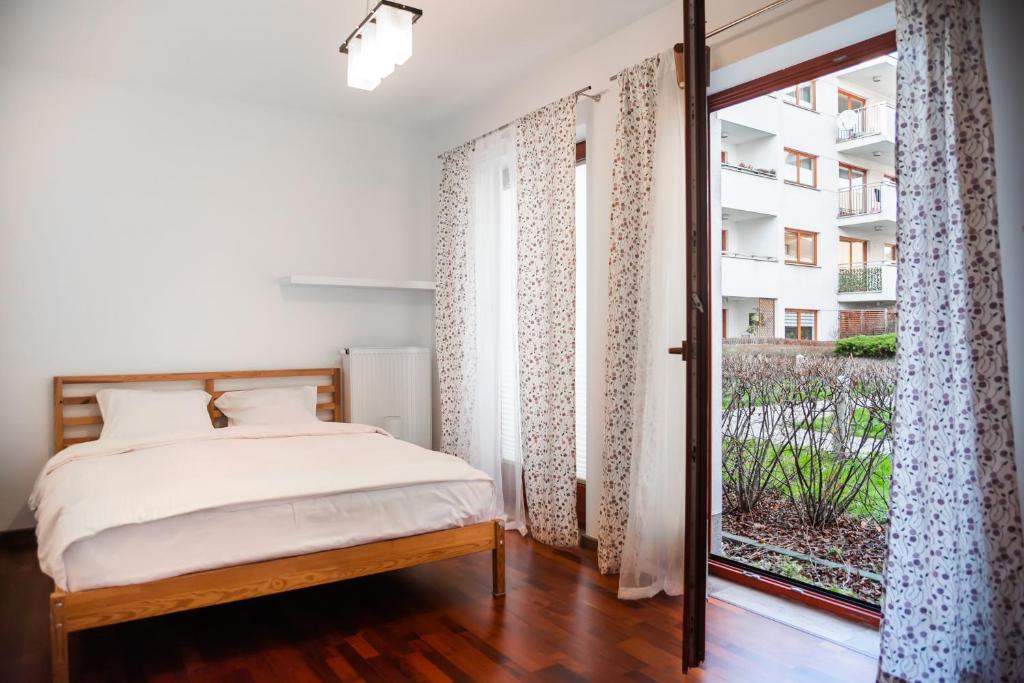 1 dormitorio con cama y ventana grande en Malborska Lovely Apartment, en Varsovia
