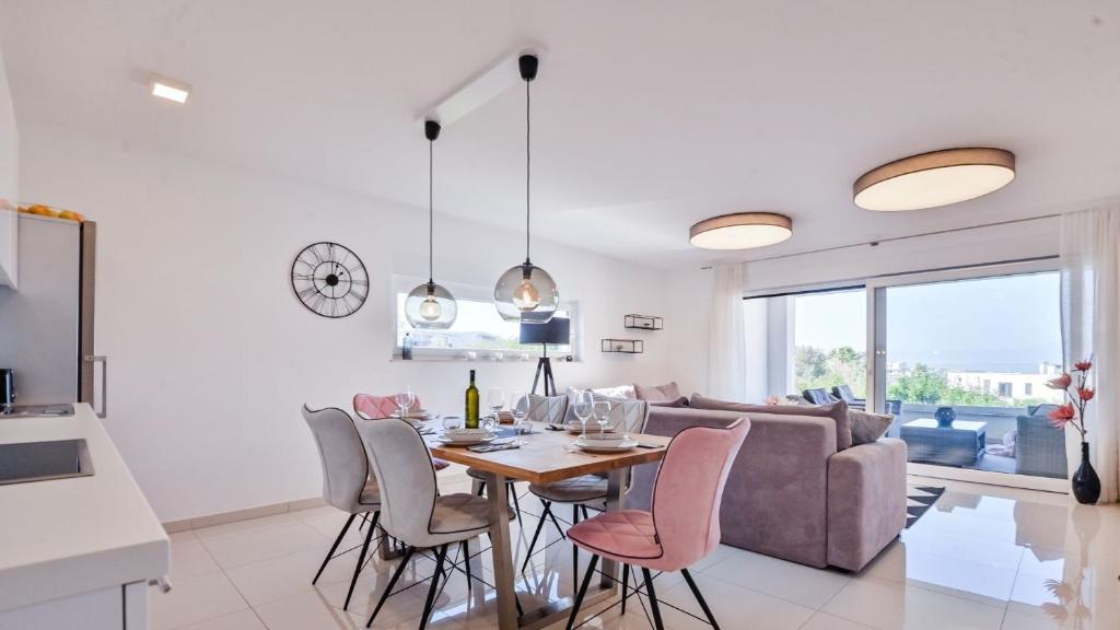 kuchnia i salon ze stołem i krzesłami w obiekcie Modern Adora Apartment w mieście Malinska