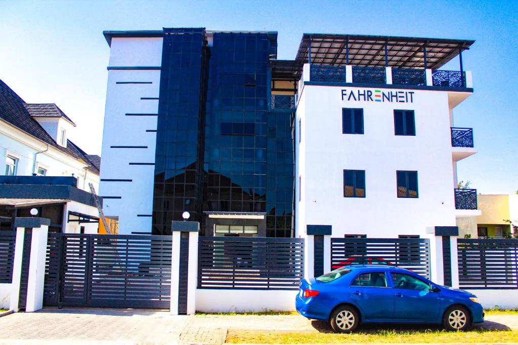 un coche azul estacionado frente a un edificio en Fahrenheit Apartments, en Abuja