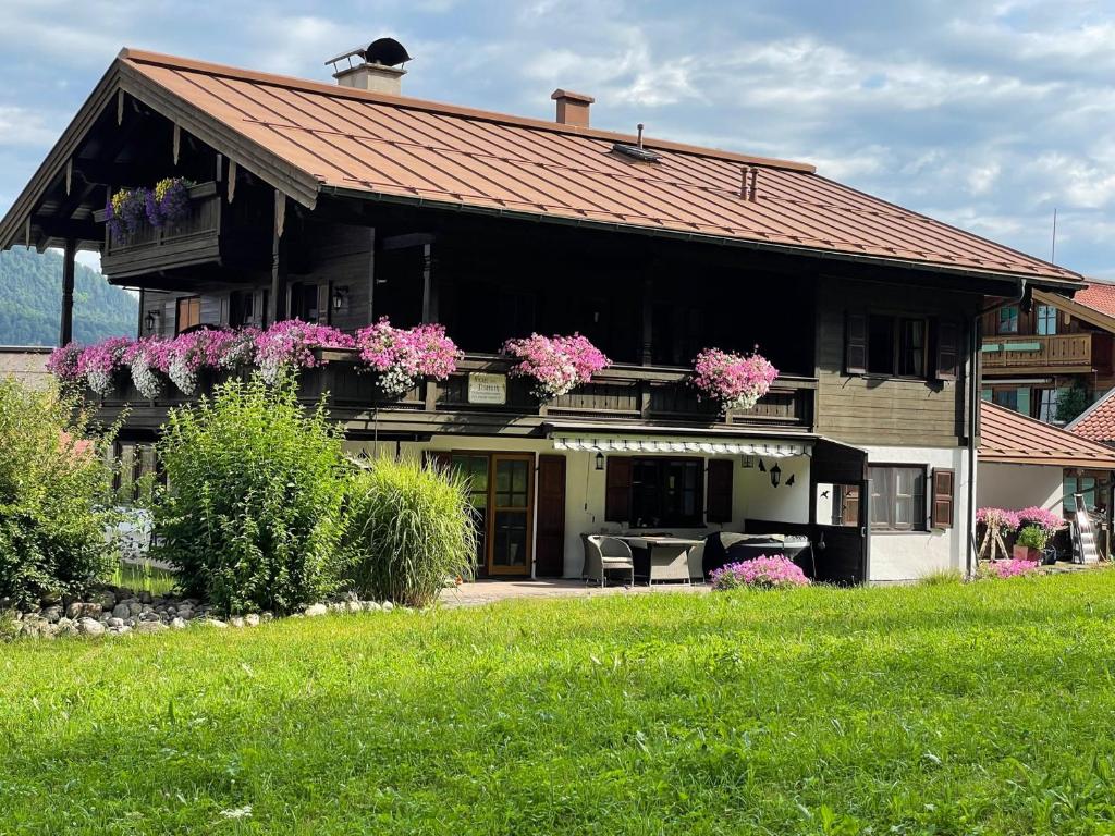una casa con flores rosas en la parte delantera en Haus am Dürrach, en Reit im Winkl