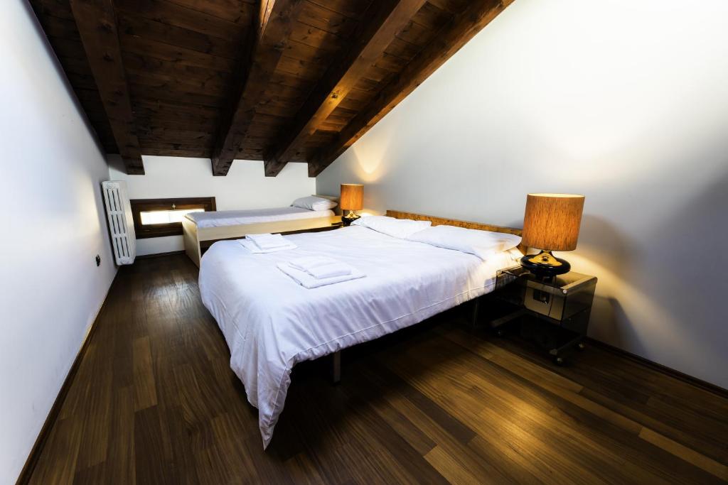 1 dormitorio con cama blanca grande y techo de madera en Palazzo Regina, en Verona