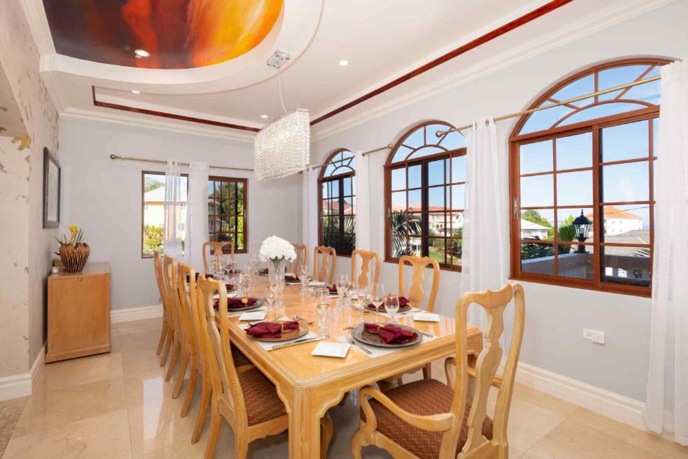 a dining room with a wooden table and chairs at Villa De-Luxe Paradise in Discovery Bay