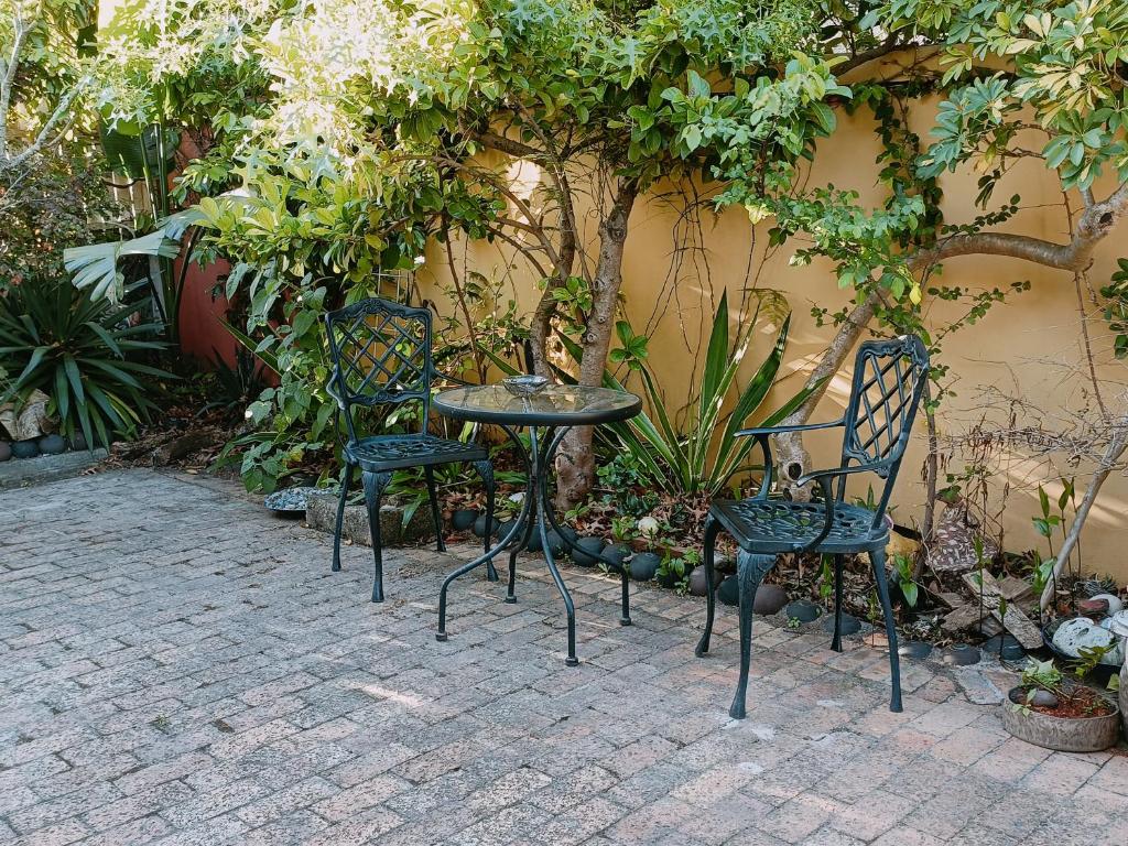 3 sillas y una mesa en un patio en John Bauer Pottery Studio, en Ciudad del Cabo