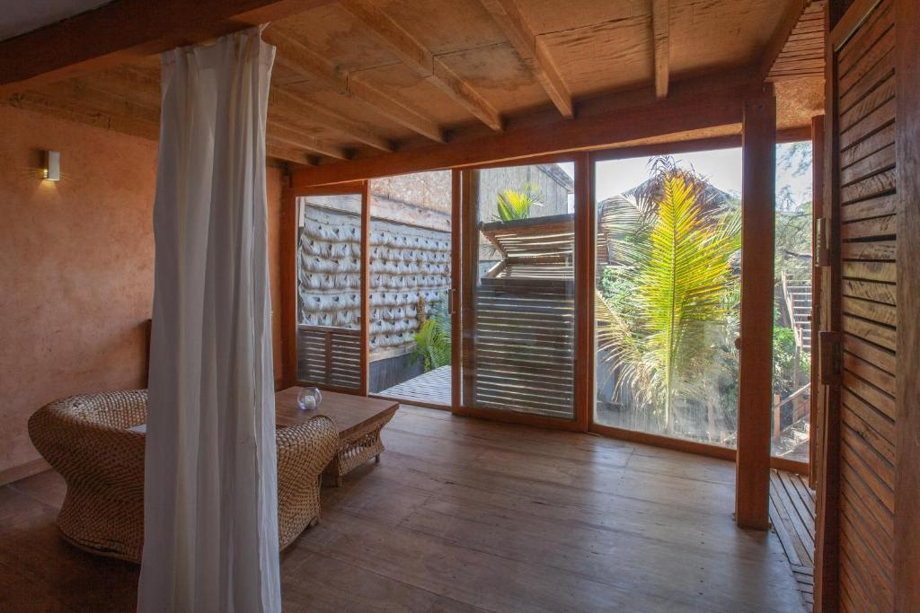 Eco Lodge Mancora في مانكورا: غرفة معيشة مع باب زجاجي كبير إلى الفناء