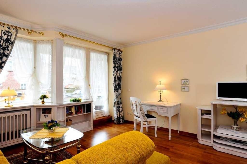 uma sala de estar com um sofá amarelo e uma mesa em Margaretheneck - Sylter Sand em Westerland
