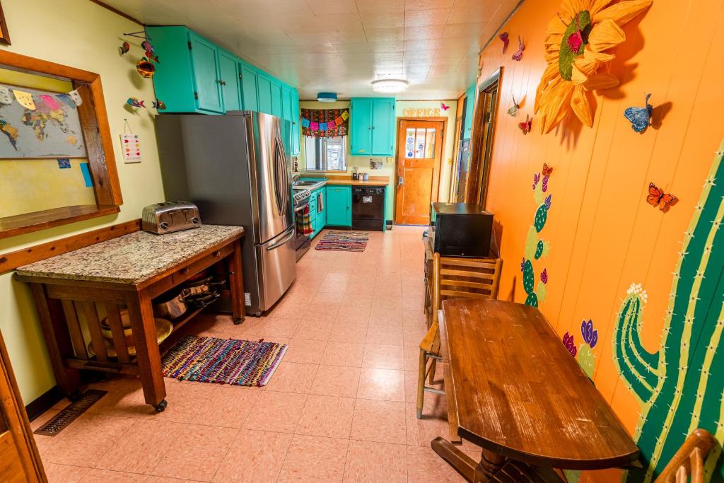 a kitchen with a wooden table and a refrigerator at The Wanderlust Hostel in Gunnison